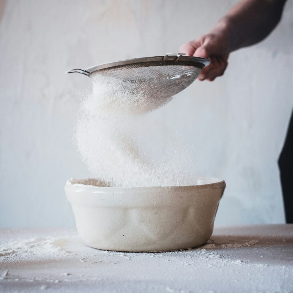 person pouring water on white ceramic bowl